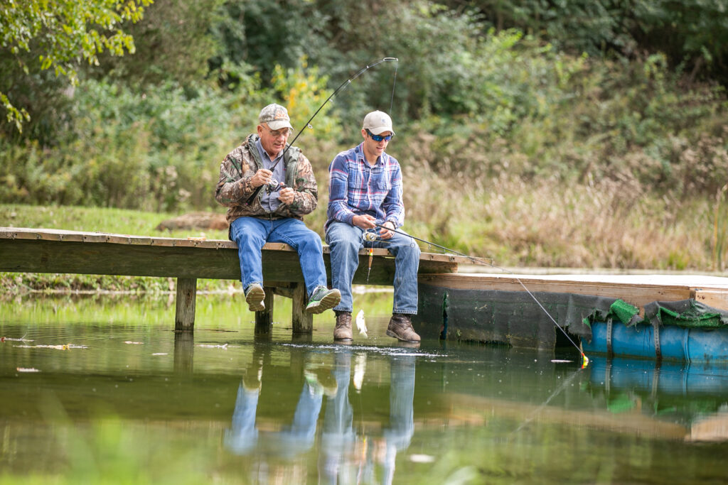 An elderly man and his grandson sitting on a dock in Columbus fishing